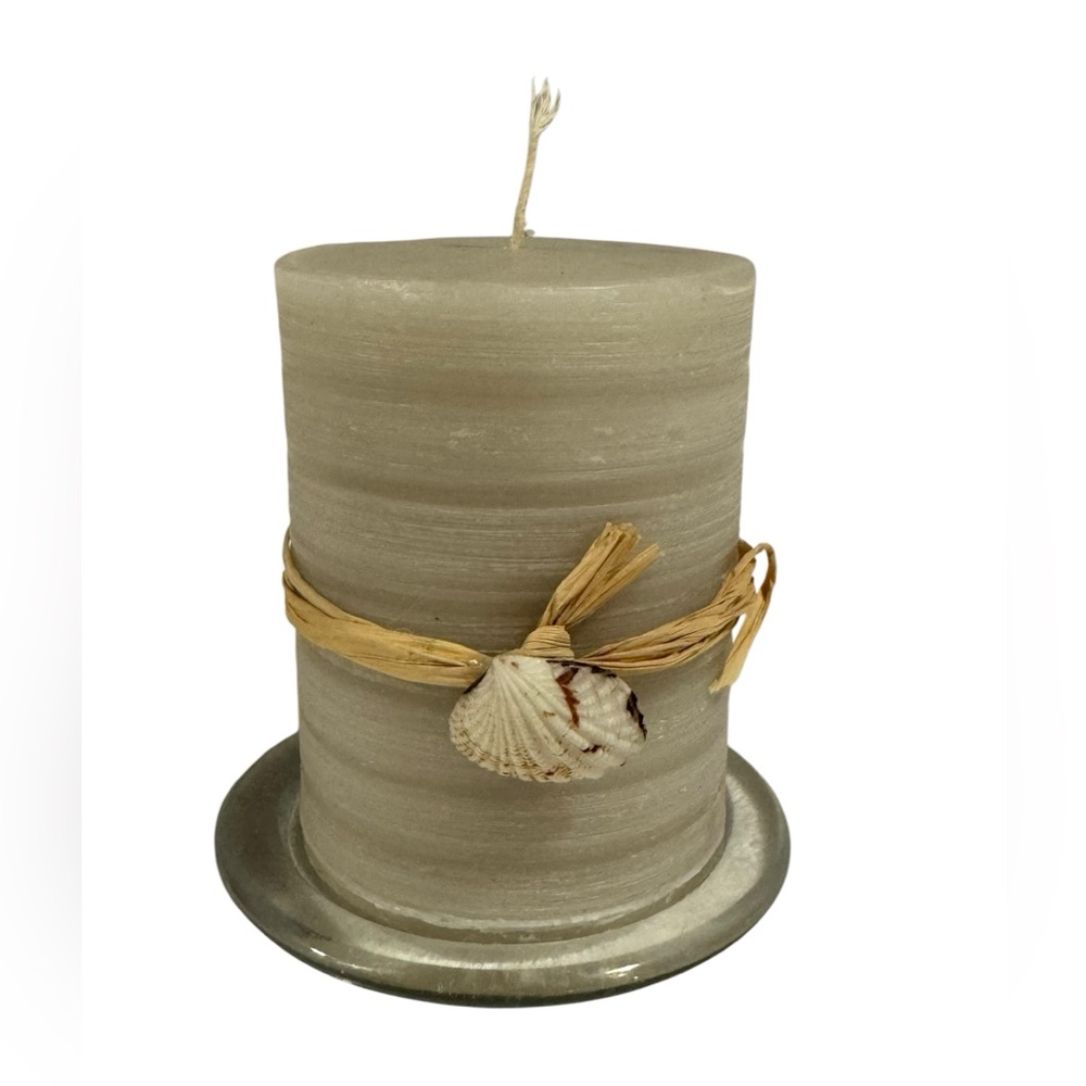 Grey Target brand 3 x 4 pillar candle on glass plate with seashell accent